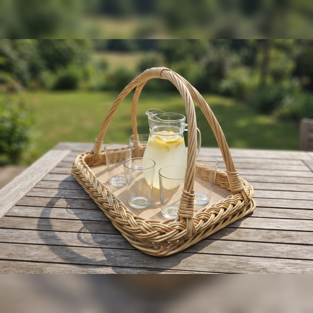 Vytelių padėklas su rankenomis ant medinio sodo stalo, ant jo stiklinis ąsotis limonado ir stiklinės