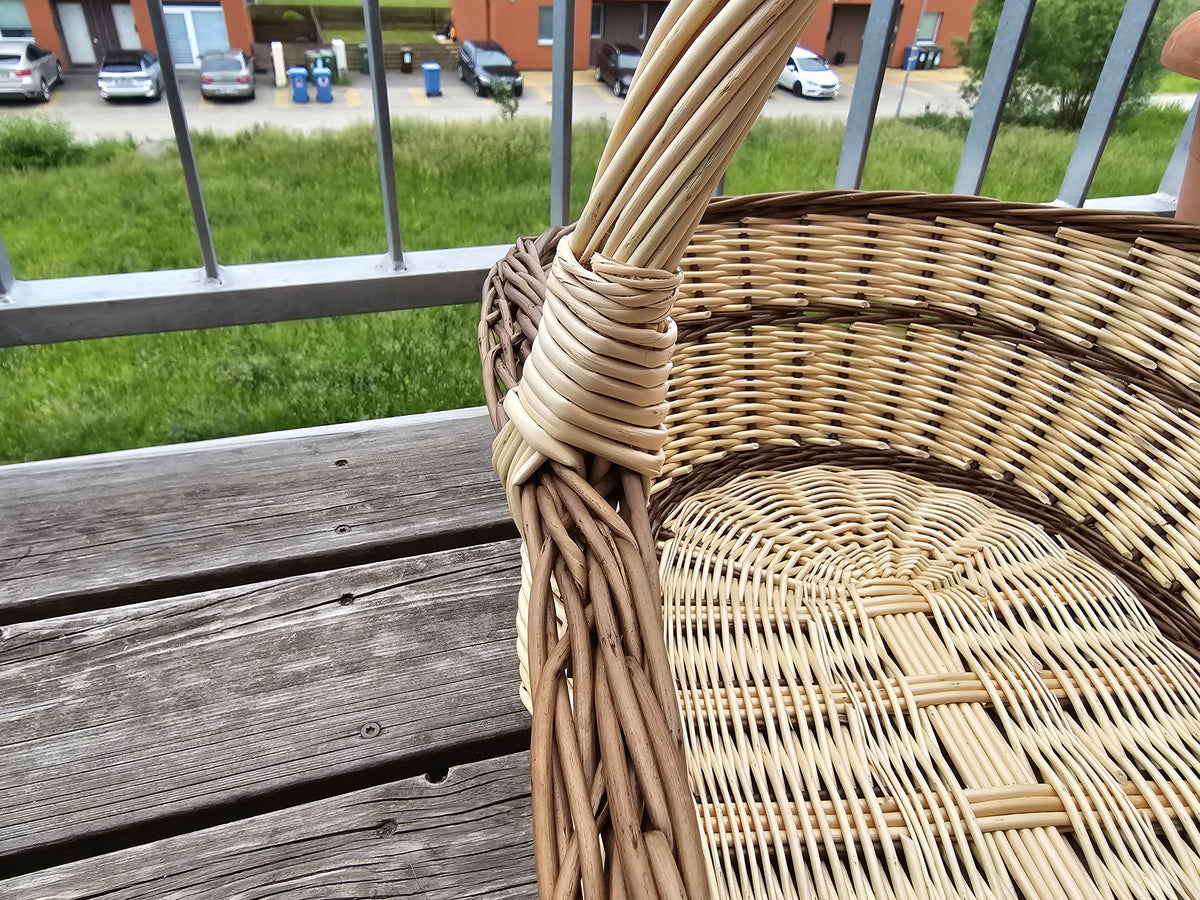 Iš arti: susukta rankena įpinta į kraštą, viduje matyti ovalus pintas dugnas