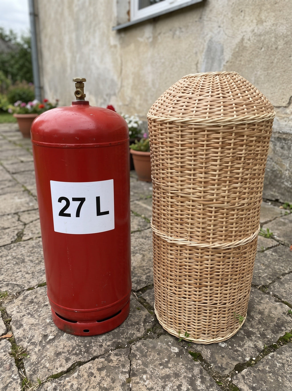 60 cm pintas gaubtas šalia raudono 27 l dujų baliono ant akmeninės terasos – matyti mažesnis dydis
