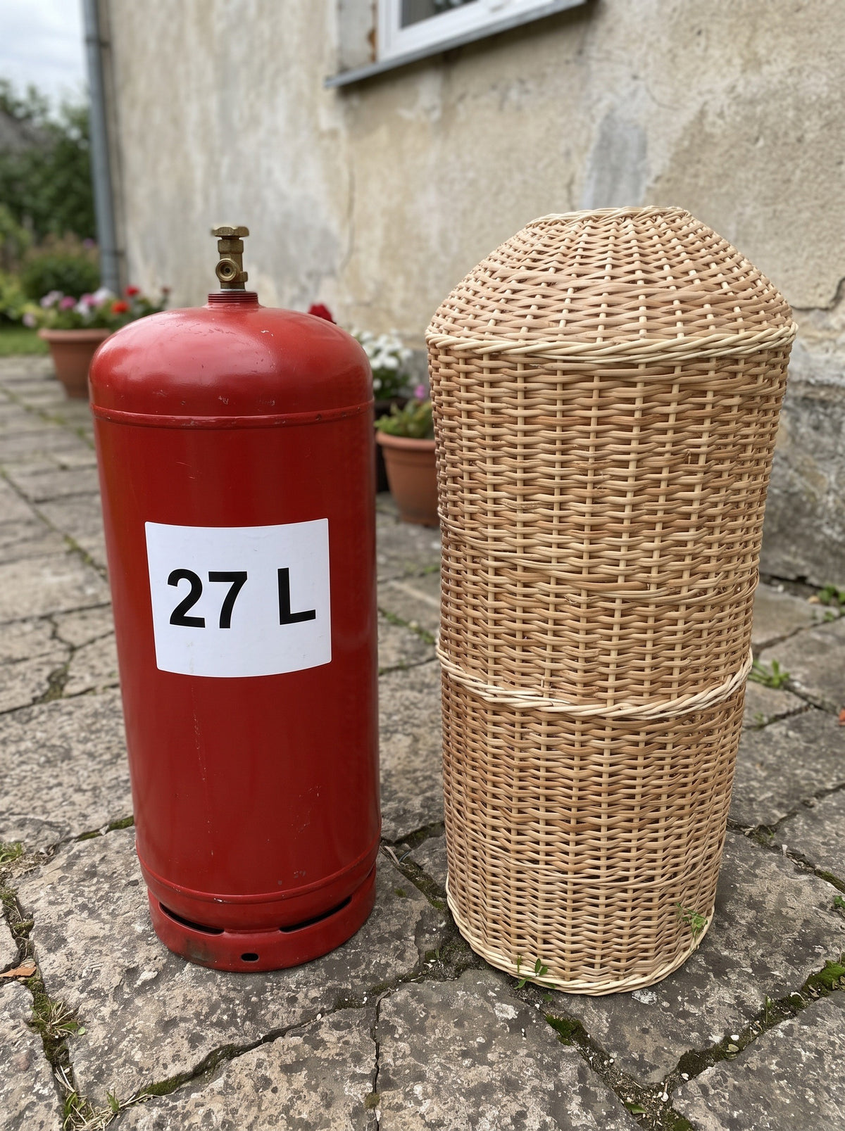 60 cm pintas gaubtas šalia raudono 27 l dujų baliono ant akmeninės terasos – matyti mažesnis dydis