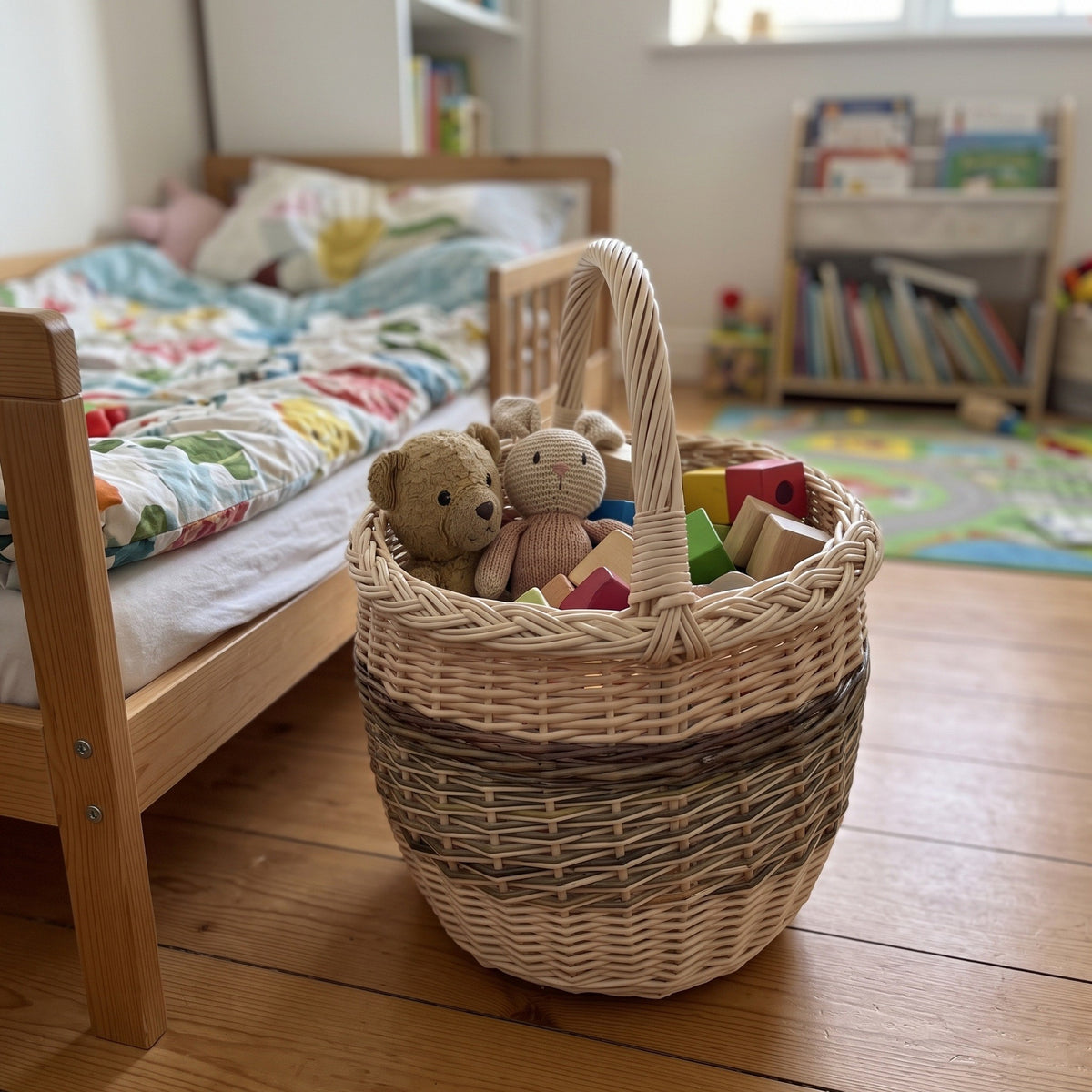 Pintinė su aukšta rankena vaikų kambaryje prie lovos, joje meškiukai ir medinės kaladėlės