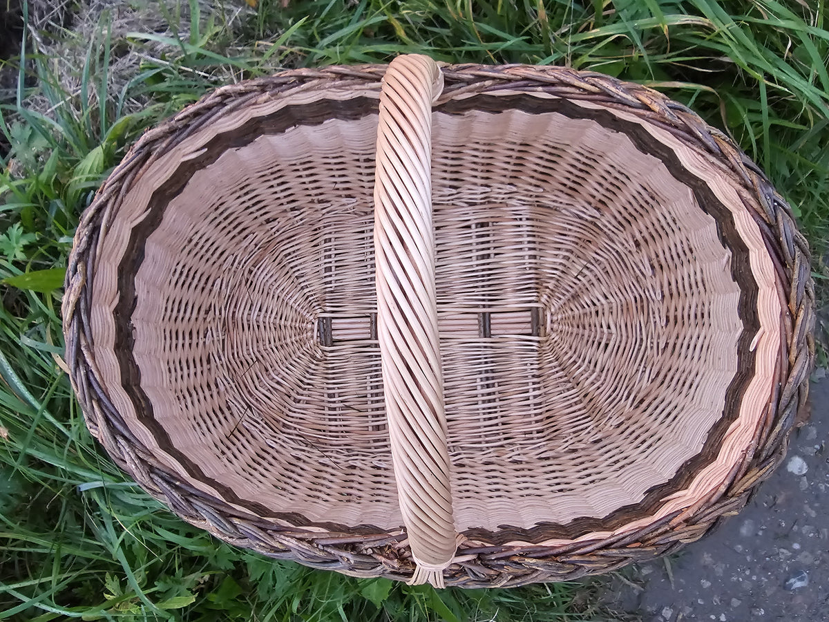 Top view inside the large oval willow basket showing the woven base and the arched handle