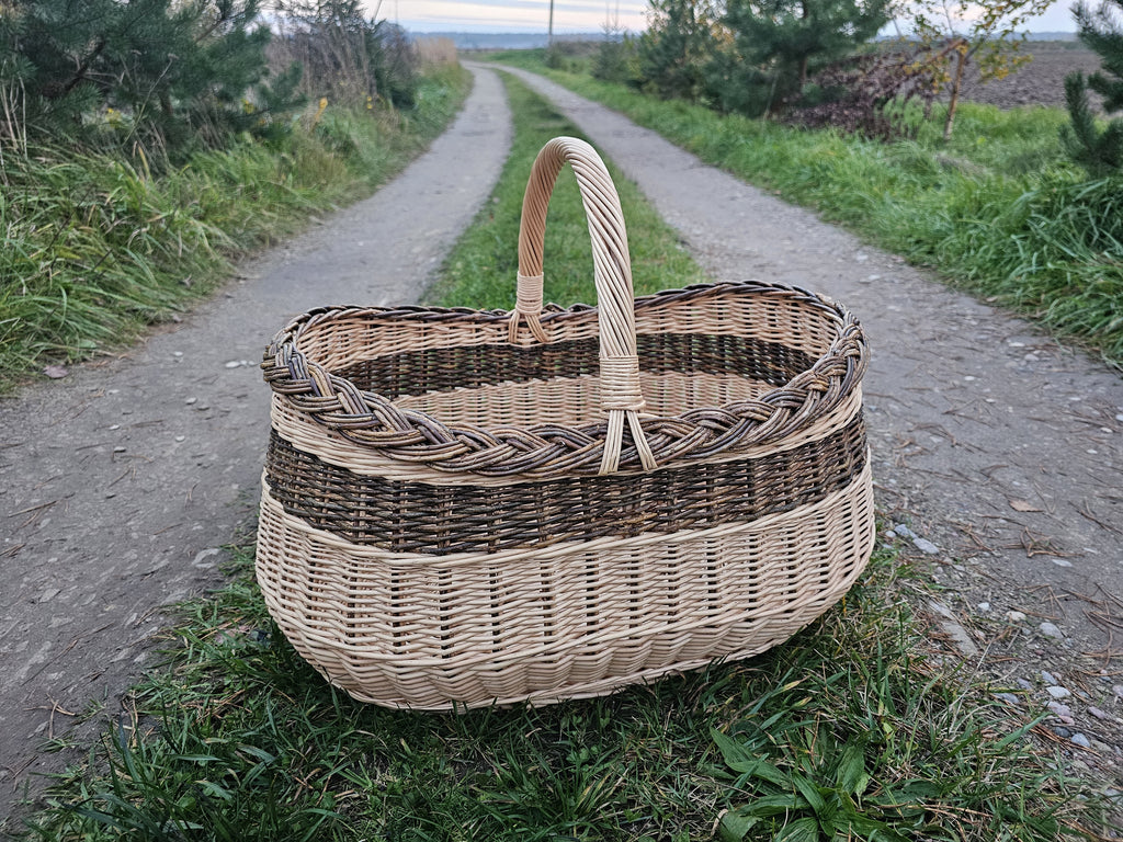 Large oval willow basket on a gravel path between fields
